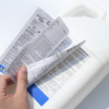 Multi-layer booklet label opened to show information panels on a container